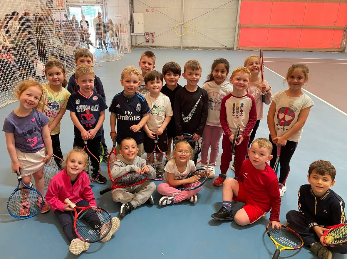 Les enfants de l’école de tennis réunis sur un court couvert